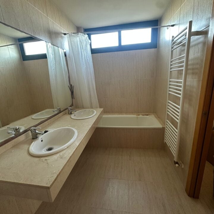 Los propietarios de esta vivienda sentían que su cuarto de baño se había quedado atrapado en el tiempo. A pesar de tener metros cuadrados suficientes, la estancia se sentía pesada y oscura, dominada por un revestimiento de mármol beige antiguo y una bañera que ya no respondía a su ritmo de vida actual.