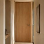Las puertas hasta el techo se han convertido en uno de los recursos más reconocibles de las reformas contemporáneas. Su éxito no responde solo a una cuestión estética. Al eliminar el dintel tradicional, la pared se percibe más alta, limpia y continua, algo especialmente valioso en viviendas con techos estándar o pasillos estrechos.